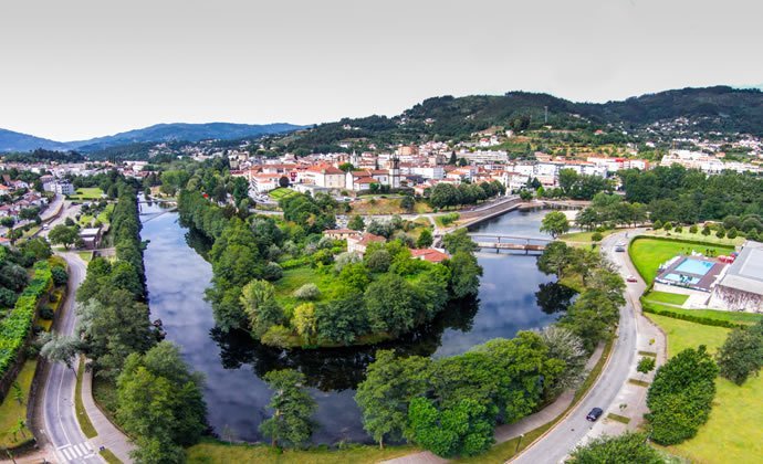 A imagem mostra uma vista a&eacute;rea da vila de Arcos de Valdevez, sobressaindo o verde da vegeta&ccedil;&atilde;o e o azul do rio Vez